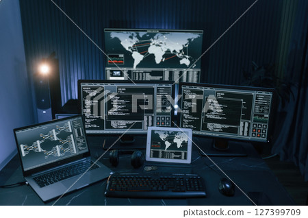 Multiple screens with information. Cyber criminal haker dark room for massive attack of corporate big data servers 127399709