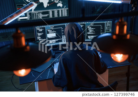 Light bulbs. Young professional female hacker is indoors by computer with lot of information on displays 127399746