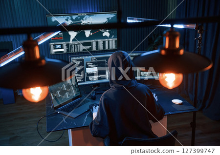 Light bulbs. Young professional female hacker is indoors by computer with lot of information on displays 127399747