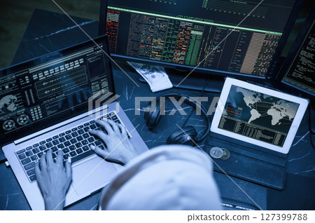 Blue neon light. Young professional female hacker is indoors by computer with lot of information on displays 127399788