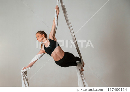 Young beautiful woman doing fly yoga against white background 127400134