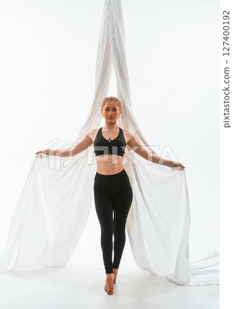 Young beautiful woman doing fly yoga against white background 127400192