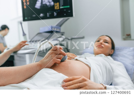 Close up view, scanning. Pregnant woman is lying down in the hospital, doctor does ultrasound Close up view, scanning. Pregnant woman is lying down in the hospital, doctor does ultrasound 127400691