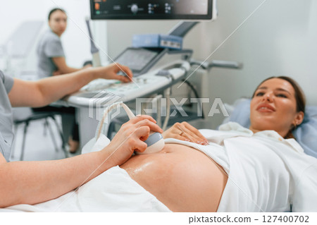 Focused close up view. Pregnant woman is lying down in the hospital, doctor does ultrasound 127400702