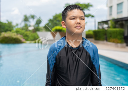 Teenage boy ready to swim in swimming pool 127401152