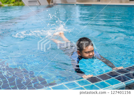 Teenage boy ready to swim in swimming pool 127401156