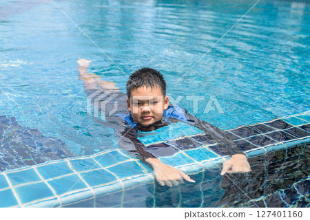 Teenage boy ready to swim in swimming pool 127401160