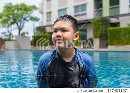 Teenage boy ready to swim in swimming pool 127401167