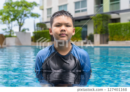Teenage boy ready to swim in swimming pool 127401168