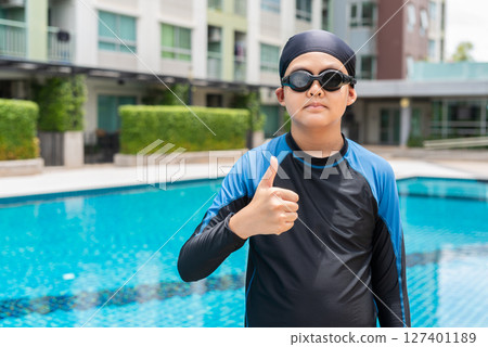 Teenage boy with goggles ready to swim in swimming pool Teenage boy with goggles ready to swim in swimming pool 127401189
