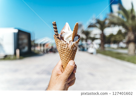 Ice Cream Cone on a Sunny Seaside Promenade 127401602