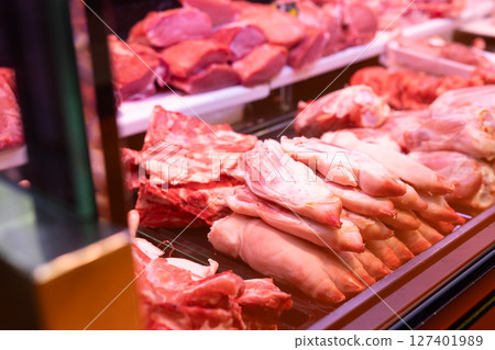Display case in meat department of supermarket - raw pork legs are stacked 127401989