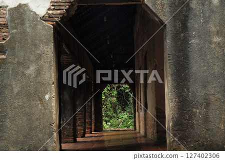 Corridor of the old Buddhism church with the forest at the end 127402306