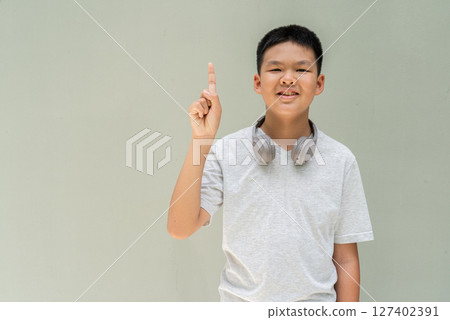 Thai Boy Portrait Against Plain Wall in Natural Light Thai Boy Portrait Against Plain Wall in Natural Light 127402391