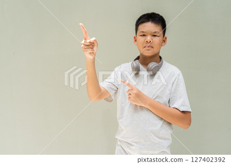 Thai Boy Portrait Against Plain Wall in Natural Light 127402392