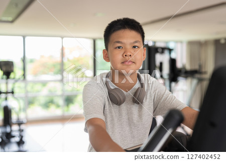 Young Teen Boy Working Out on Exercise Bike 127402452