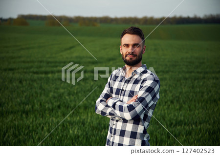 Spring season. Handsome young man is on agricultural field Spring season. Handsome young man is on agricultural field 127402523