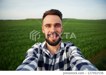 Making selfie. Handsome young man is on agricultural field 127402536