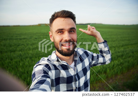 Making selfie. Handsome young man is on agricultural field 127402537