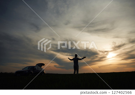 Silhouette of a man that is in the field at sunset time. Dramatic sky Silhouette of a man that is in the field at sunset time. Dramatic sky 127402566