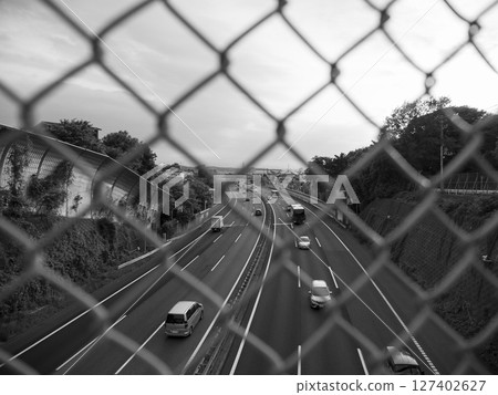 Fence and highway. Tomei Expressway. Monochrome. 127402627