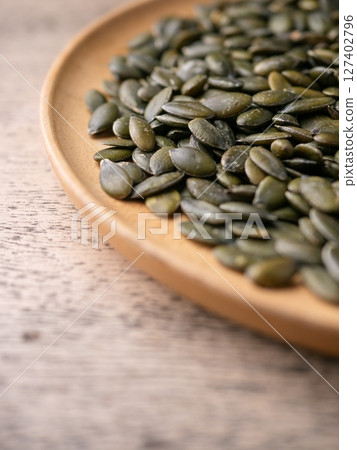 Peeled dry pepita pumpkin seeds background. Peeled dry pepita pumpkin seeds background. 127402796