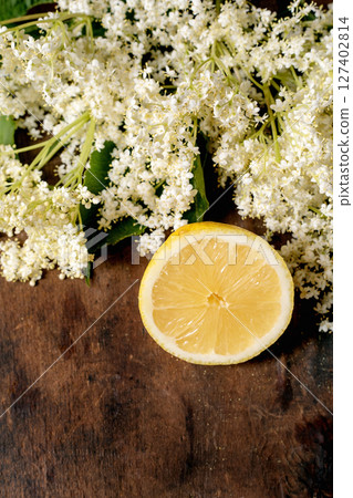 Fresh elderflower clusters with lemon slice on wooden background. Natural ingredients for homemade syrup tea traditional recipes 127402814