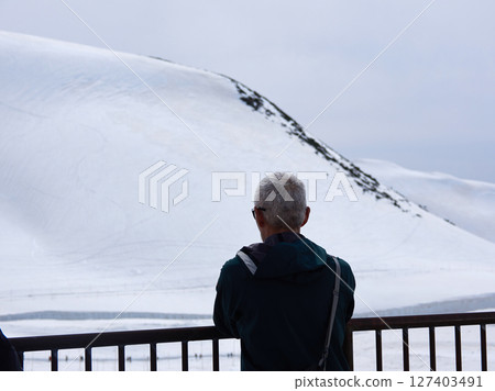 Senior tourists looking at the snowy scenery at Murodo on the tourist spot Tateyama Kurobe Alpine Route Senior tourists looking at the snowy scenery at Murodo on the tourist spot Tateyama Kurobe Alpine Route 127403491