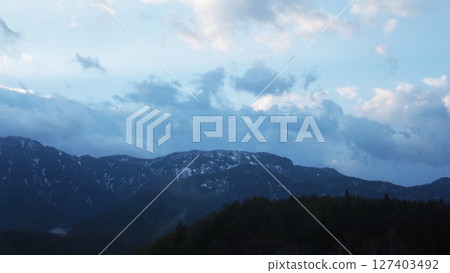 Snowy scenery of the Tateyama mountain range and fog in the forest on a spring morning Snowy scenery of the Tateyama mountain range and fog in the forest on a spring morning 127403492