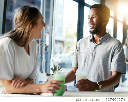 Restaurant, date and couple drinking milkshake while talking, bonding and laughing together. Happy, love and interracial man and woman in conversation while enjoying smoothie at a cafe in the city. 127404274