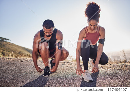 Fitness couple, running shoes and exercise on a road outdoor for cardio workout and training together for health and wellness. Black woman and man tying shoelace or sneakers for a agile run Fitness couple, running shoes and exercise on a road outdoor for cardio workout and training together for health and wellness. Black woman and man tying shoelace or sneakers for a agile run 127404407