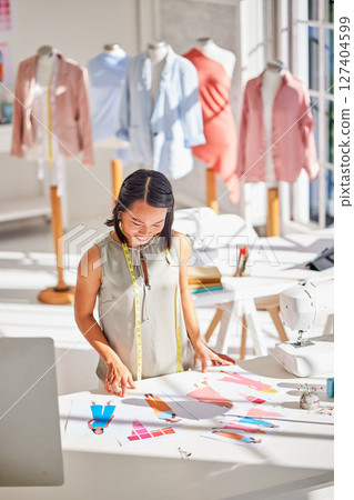 Planning, fashion and designer creative with clothes design, drawing or sketch with retail, tailor or industry. Factory, ecommerce or paper with asian woman employee in workshop for studio boutique Planning, fashion and designer creative with clothes design, drawing or sketch with retail, tailor or industry. Factory, ecommerce or paper with asian woman employee in workshop for studio boutique 127404599