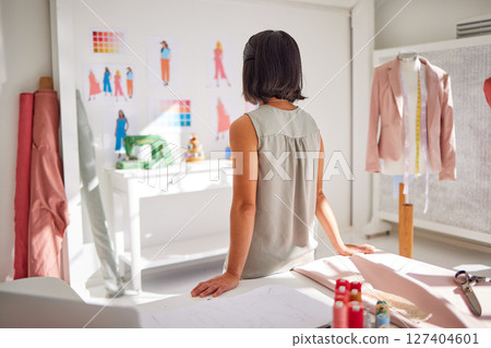 Fashion, thinking and designer back of woman planning textile fabric design or luxury outfit. Creative industry, small business and girl working on tailor clothes idea in atelier workshop studio 127404601