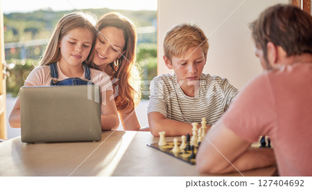 Family, parents and kids with laptop, chess and learning together in home for fun, education and bonding. Dad, children and board games for mind, strategy and development with pc, mother and daughter 127404692