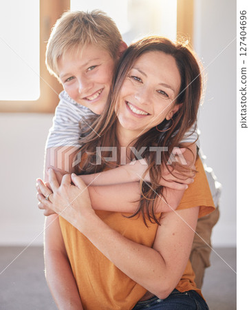 Mother, hug and kid in a family home together with happiness, bonding and parent care. Portrait of a mom and child in a house with love and happy child care smiling and hugging in a living room 127404696