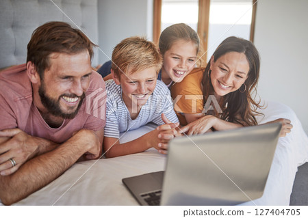 Laptop, family and children with a mother, father and kids bonding while watching a movie in a home bedroom. Computer, bed and streaming with a brother, sister and parents spending time together 127404705