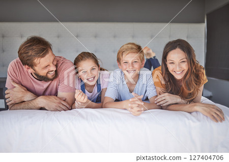 Happy, relax and portrait of a family on a bed for love, peace and calm in their house together. Smile, happiness and comfort for children with their mother and father in the bedroom of their home 127404706