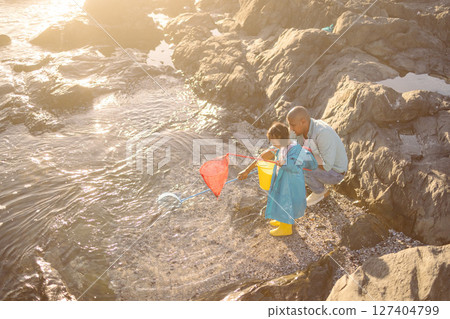 Father, kid and fishing net at beach, ocean and sea for learning, development and adventure, summer holiday and sunshine vacation. Girl child catching fish with parent in nature, rock pool and water Father, kid and fishing net at beach, ocean and sea for learning, development and adventure, summer holiday and sunshine vacation. Girl child catching fish with parent in nature, rock pool and water 127404799