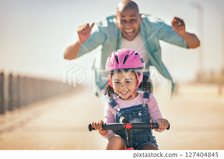 Excited father teaching girl to ride a bike in sunshine, summer fun and beach promenade outdoors. Happy kid, learning and riding bicycle with help from dad, parent and safety for healthy development Excited father teaching girl to ride a bike in sunshine, summer fun and beach promenade outdoors. Happy kid, learning and riding bicycle with help from dad, parent and safety for healthy development 127404845