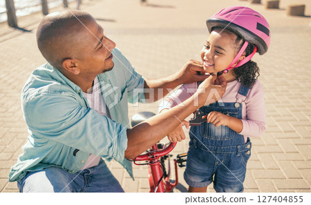 Father, child and safety helmet while outdoor with bicycle on the promenade for fun and quality time while learning to ride a bike. Man and girl family together for training and development in summer Father, child and safety helmet while outdoor with bicycle on the promenade for fun and quality time while learning to ride a bike. Man and girl family together for training and development in summer 127404855
