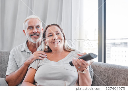 Senior couple, watching tv and relax on sofa in living room together for happy retirement. Love, streaming television and elderly woman with retired man relaxing on couch, smile for comic movie 127404975