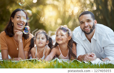 Bubbles, happy and family in the park for a picnic, relax and quality time on the grass in Canada. Spring, smile and portrait of girl children with mother and father with love and care in nature Bubbles, happy and family in the park for a picnic, relax and quality time on the grass in Canada. Spring, smile and portrait of girl children with mother and father with love and care in nature 127405055
