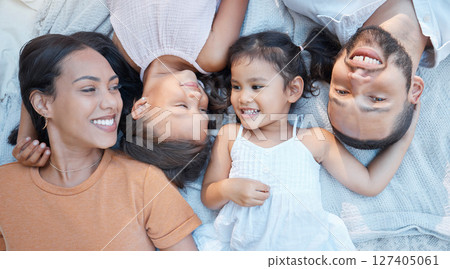 Happy family, love and care of parents for children lying on a blanket for bonding, quality time and support. Black man, woman and kids from top together on a picnic for fun, relax and portrait 127405061