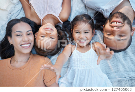 Family, children and love with a mother, father and girl siblings lying on the ground together from above. Kids, floor and happy with a woman, man and daughter sisters bonding while outdoor to relax 127405063