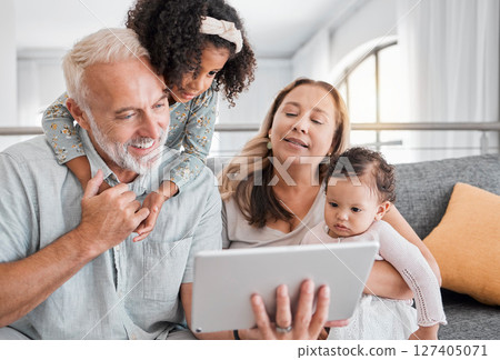 Relax, tablet and grandparents with children on sofa for movie, cartoon or educational app online. Grandmother, grandpa and kids streaming entertainment in interracial family home in Mexico. 127405071