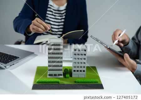 House model with agent asking costumer for contract to buy, get insurance or loan real estate or property. House model with agent asking costumer for contract to buy, get insurance or loan real estate or property. 127405172