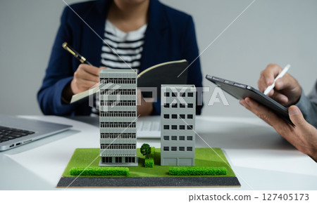 House model with agent asking costumer for contract to buy, get insurance or loan real estate or property. House model with agent asking costumer for contract to buy, get insurance or loan real estate or property. 127405173