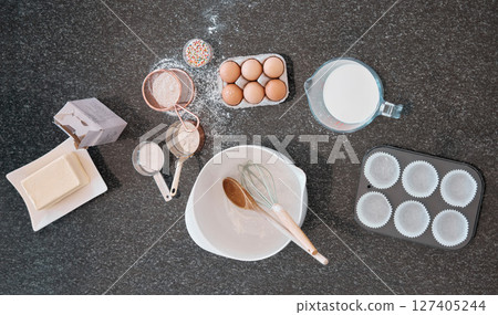 Top view, baking product and kitchen counter with eggs, flour and butter utensils on table. Food and cooking ingredients on a table to bake meal or dessert with protein and nutrients from above Top view, baking product and kitchen counter with eggs, flour and butter utensils on table. Food and cooking ingredients on a table to bake meal or dessert with protein and nutrients from above 127405244