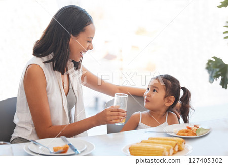 Woman, food and eating at home for health, wellness and diet nutrition at the dining table. Meal, lunch and mother and daughter eat and drink juice together for hungry child in the family home Woman, food and eating at home for health, wellness and diet nutrition at the dining table. Meal, lunch and mother and daughter eat and drink juice together for hungry child in the family home 127405302