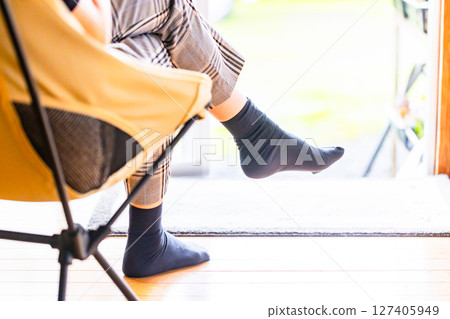 Back view of a woman relaxing in a chair on the veranda 127405949